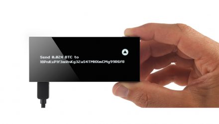 A hand holding the wallet that is making a BTC transaction